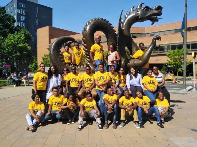 Image of the Fellows wearing Drexel t-shirts in front of Mario the Dragon